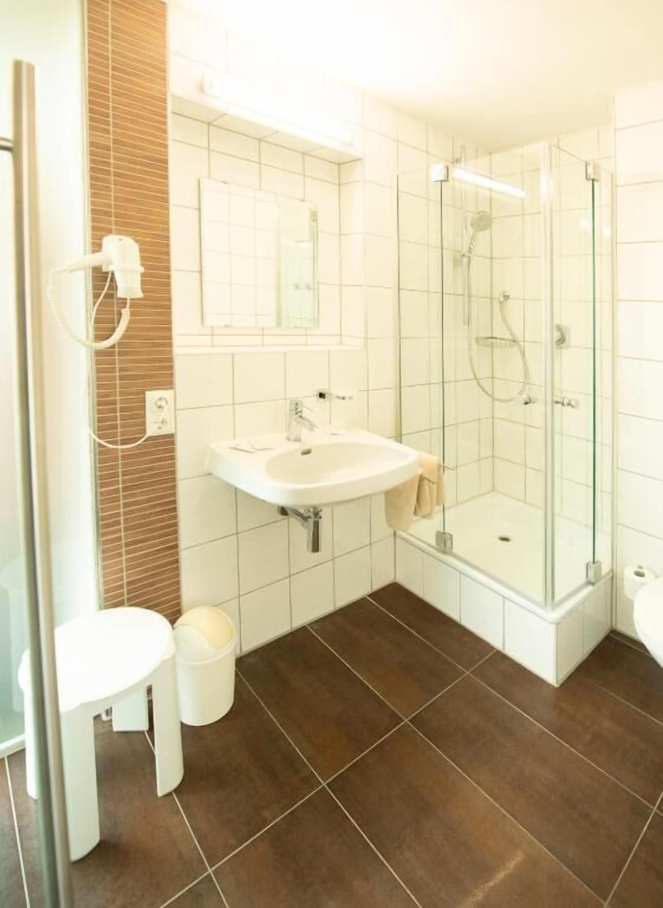 Standaard tweepersoonskamer, uitzicht op tuin | Badkamer | Een douche, een haardroger, handdoeken, zeep