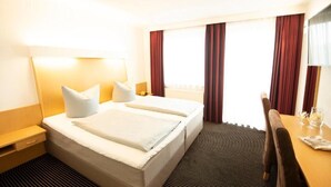 Una habitación de hotel con una cama doble, un escritorio y una silla.