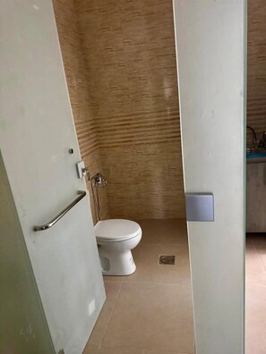 A bathroom with a white toilet, a shower area, and a visible door handle. - Studio flat in a Safe Area - near Khalidi Hospital - Minutes from City Center (Amman)