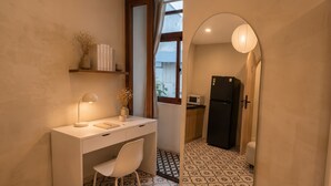 A compact kitchen with a refrigerator, microwave, and a window with curtains. - Zen Living (Ho Chi Minh City)