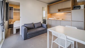 Una kitchenette compacta con microondas, un lavamanos y un refrigerador pequeño.