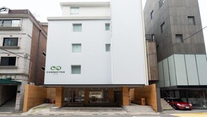 A hotel with a modern facade, a logo, and a visible entrance.