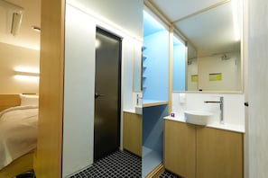 A hotel room with a bed, a door leading to a bathroom, and a mirror above the sink.