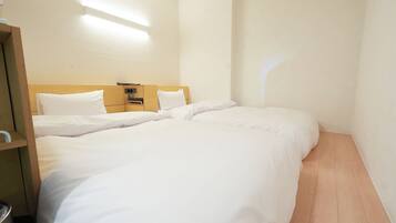 Una habitación de hotel con una cama grande, un cabecero de madera, una mesita de noche con una lámpara y una lámpara de pared.