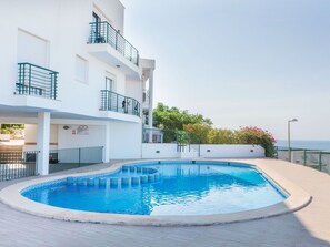 A modern building with a swimming pool, balconies, and a view of the sea. - Arabella by Interhome (Peñiscola)