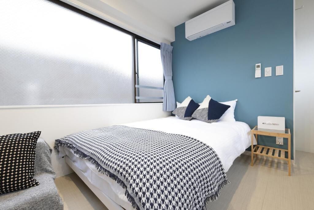A modern bedroom with a large bed, a bedside table, and a window with curtains.