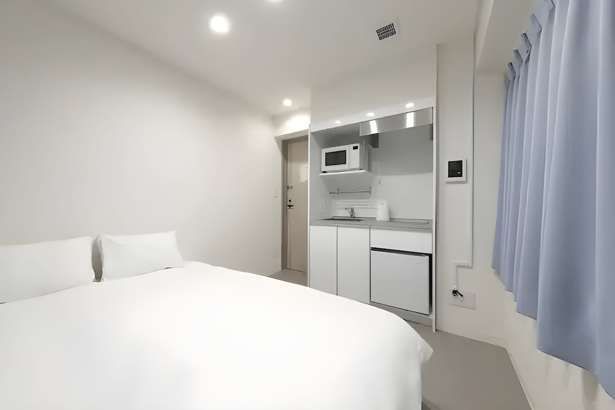 Une chambre d’hôtel comprenant un lit, une kitchenette et une salle de bain.
