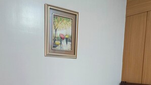 A bed with a checkered bedspread, a brown blanket, and a folded towel. - Enjoyable 1-bedroom condo with AC in Pasay City (Pasay City)