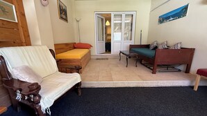 Una habitación con cama, una silla de madera, un sofá y una mesita.