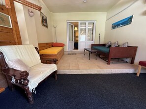 A room with a bed, a wooden chair, a sofa, and a small table. - Maslinada - Studio in peaceful fisherman village Bigova (Bigova)