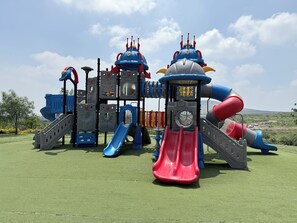 Ein Spielplatz mit Rutschen und Klettergerüsten.