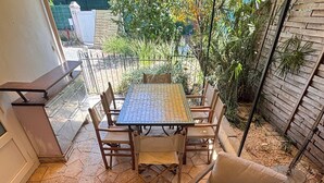 Eine Terrasse mit Tisch und Stühlen, umgeben von einem Garten.