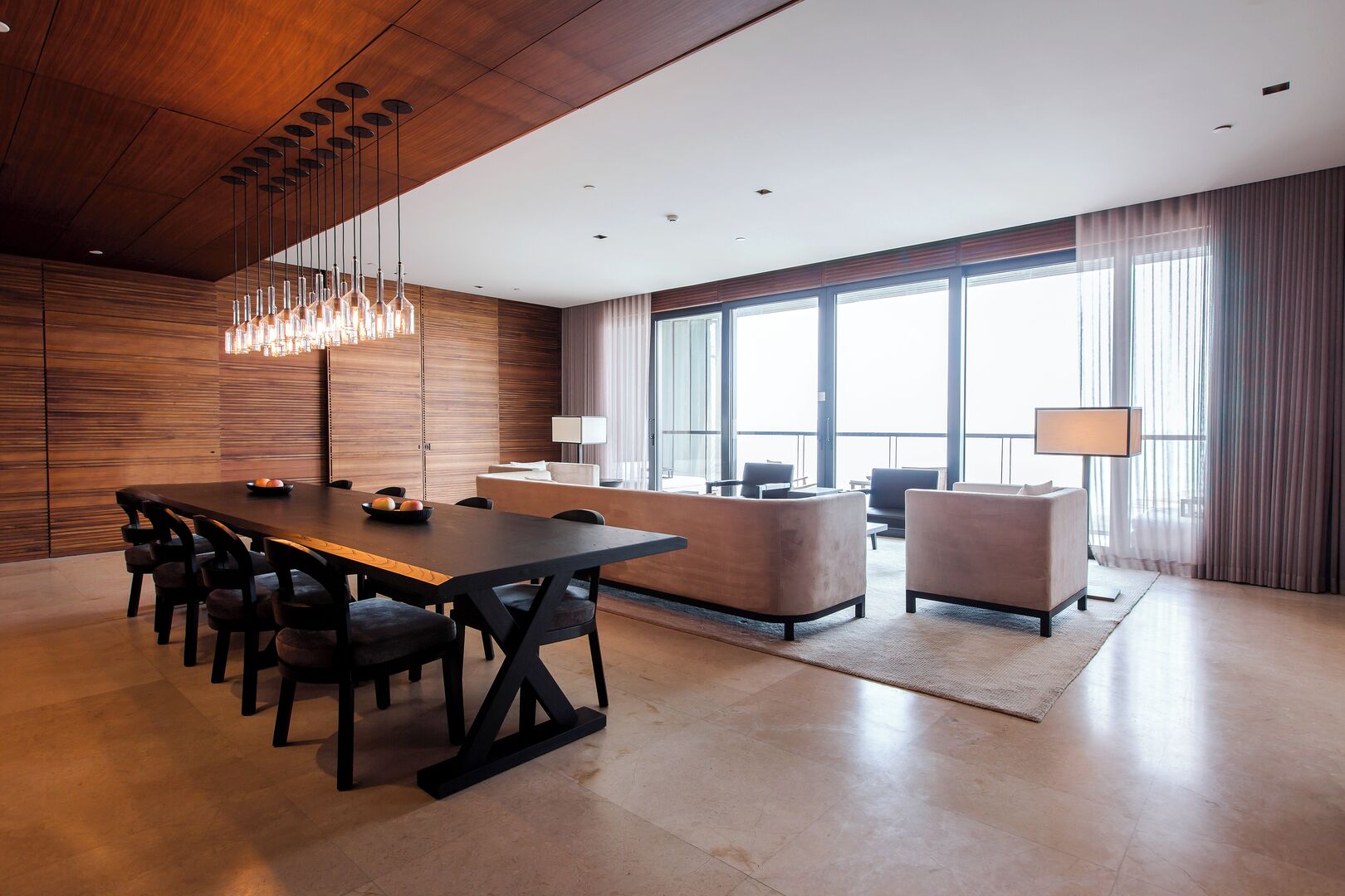 A modern conference room with a long table, chairs, a sofa, and a desk.