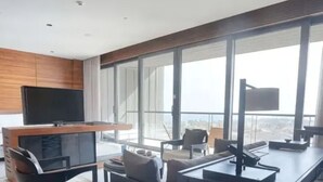 Una sala de estar moderna con una televisión de pantalla plana, un escritorio y un sofá.