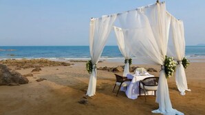 A beach wedding setup with a canopy and table. - The Lalu Qingdao (Qingdao)
