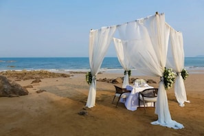 A beach wedding setup with a canopy and table.