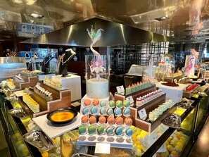 A buffet with various food items and a decorative centerpiece. - The Lalu Qingdao (Qingdao)