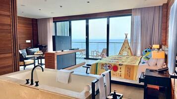 Une chambre d’hôtel avec une grande fenêtre, un lit, un bureau et une salle de bain.