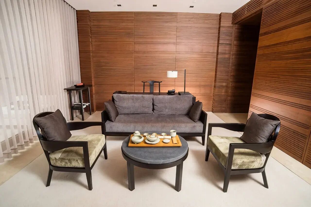 Un salon moderne avec un canapé, deux fauteuils et une table basse.