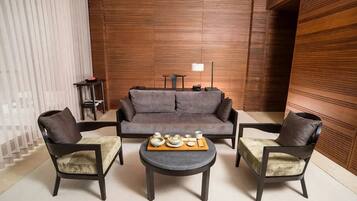 Un salon moderne avec un canapé, deux fauteuils et une table basse.