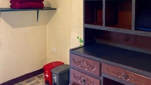 A room with a wooden dresser, a red towel on a shelf, and a patterned floor. - Casa Del Pueblo, Room Esplendor (Jardín)