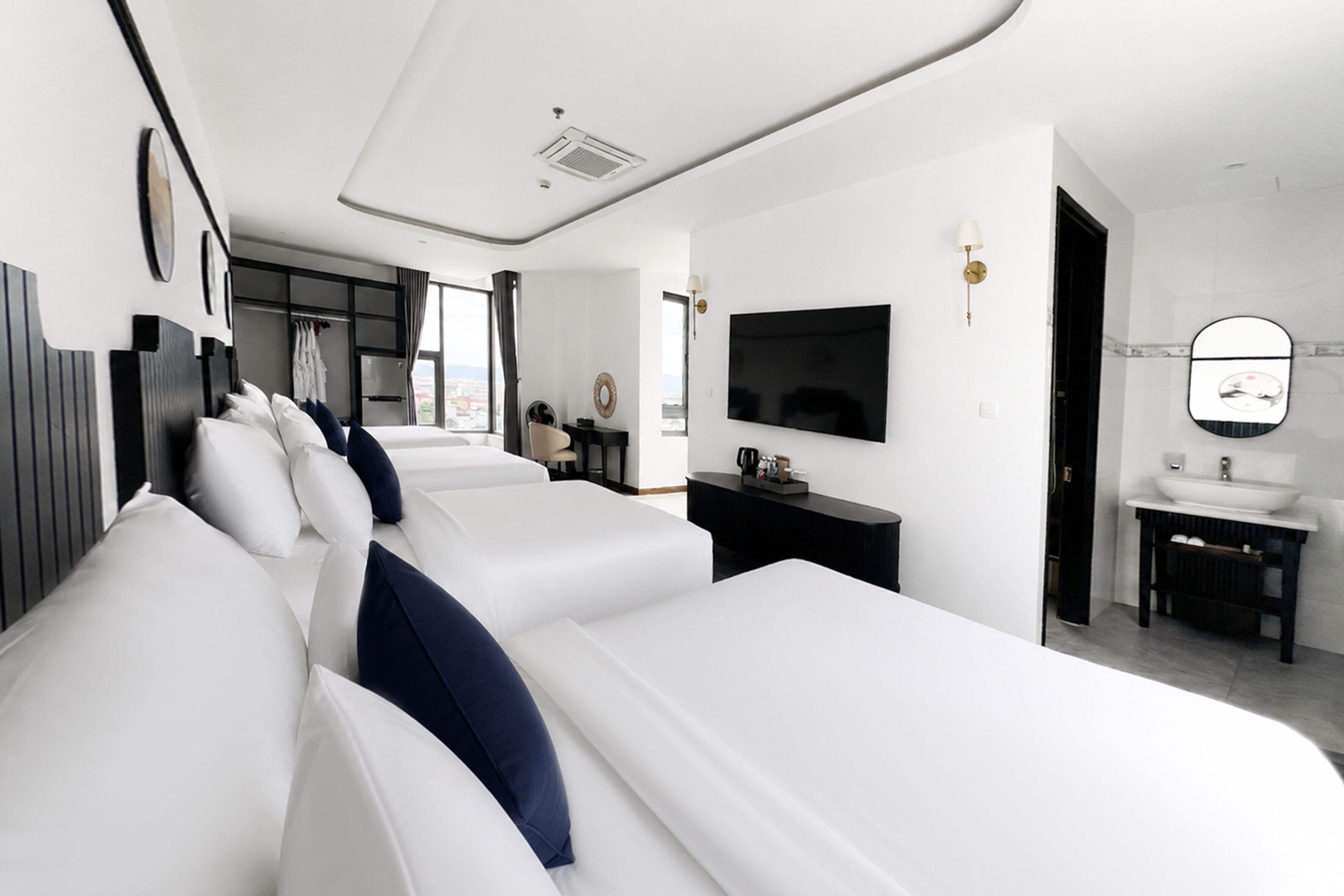 Una habitación de hotel moderna con una cama grande, televisión, escritorio y baño.