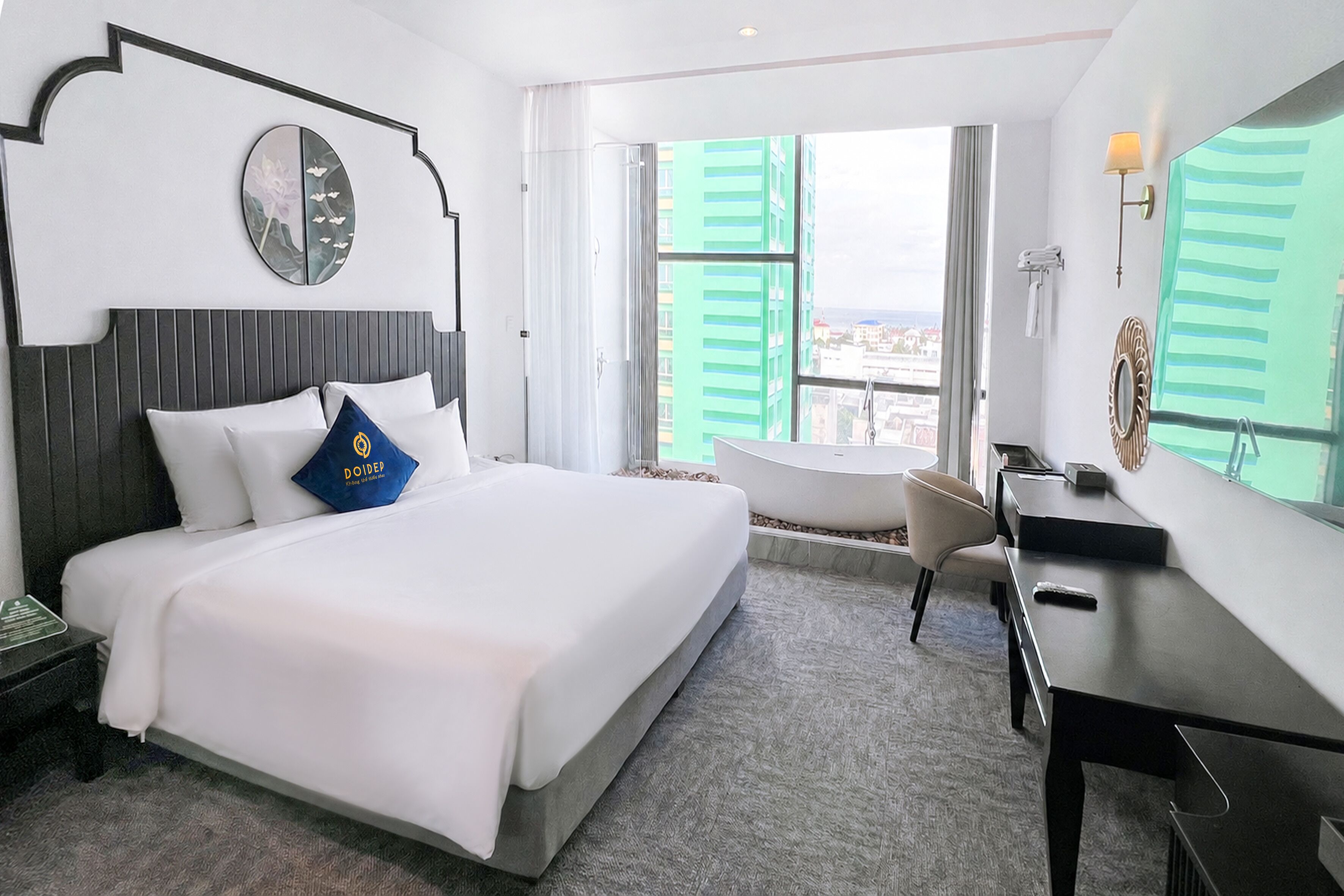 A hotel room with a bed, a desk, a chair, a window with a view, and a bathroom.