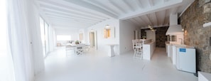 Una cocina moderna con armarios blancos, una pared de piedra y un horno empotrado.