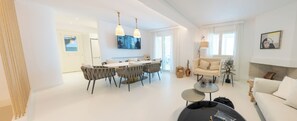 A modern living room with a dining area, a sofa, and a coffee table.