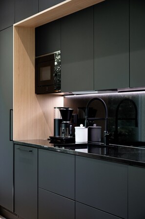 A modern kitchen with a built-in microwave, a coffee maker, and a sink. - Christmas Villa, Private Sauna By Lapland Host (Rovaniemi)