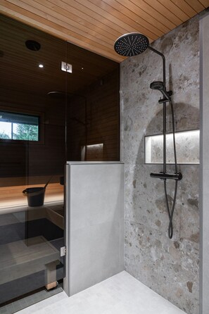 A modern shower area with a rain showerhead, a handheld showerhead, and a handheld massager. - Christmas Villa, Private Sauna By Lapland Host (Rovaniemi)