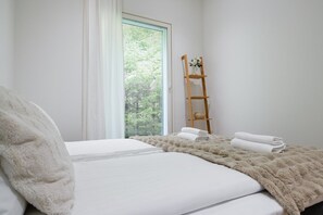 A bedroom with a bed, a window with blinds, a wooden ladder, and a vase with flowers. - Christmas Villa, Private Sauna By Lapland Host (Rovaniemi)