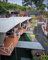 Una estructura flotante de varios niveles, que incluye un comedor con mesas y sillas, y un espacio cerrado más pequeño con una mesa y sillas.