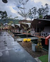 A series of tents with a covered walkway, outdoor seating, and a small garden area.