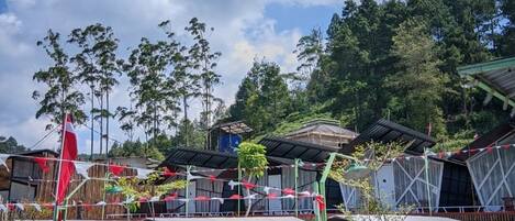 A series of tents with a view of a forested area in the background.