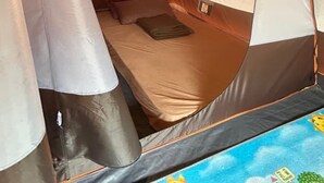 Une tente équipée d’un lit, d’un oreiller et d’une petite table.