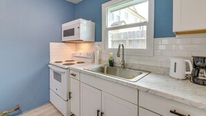 A kitchen with white cabinets, a white stove, a sink, and a window. - Dual Houston Homes: 6 Mi to NRG & Med Center (Houston)