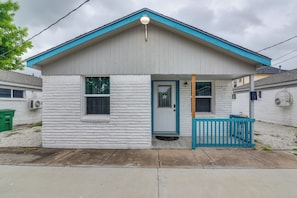 A small, single-story house with a blue roof and white exterior, featuring a front porch with a blue railing. - Dual Houston Homes: 6 Mi to NRG & Med Center (Houston)