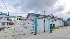 A gated property with a 'Tenant Parking Only' sign, a white fence, and a blue building. - Houston Group Stay! 2 Homes Near Museum District (Houston)