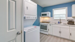 A kitchen with white appliances, a microwave, a stove, and cabinets. - Houston Group Stay! 2 Homes Near Museum District (Houston)