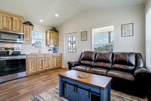 A modern kitchen with wooden cabinets, a built-in oven, and a microwave. - Tiny Home Retreat Close to Lake Granbury (Granbury)