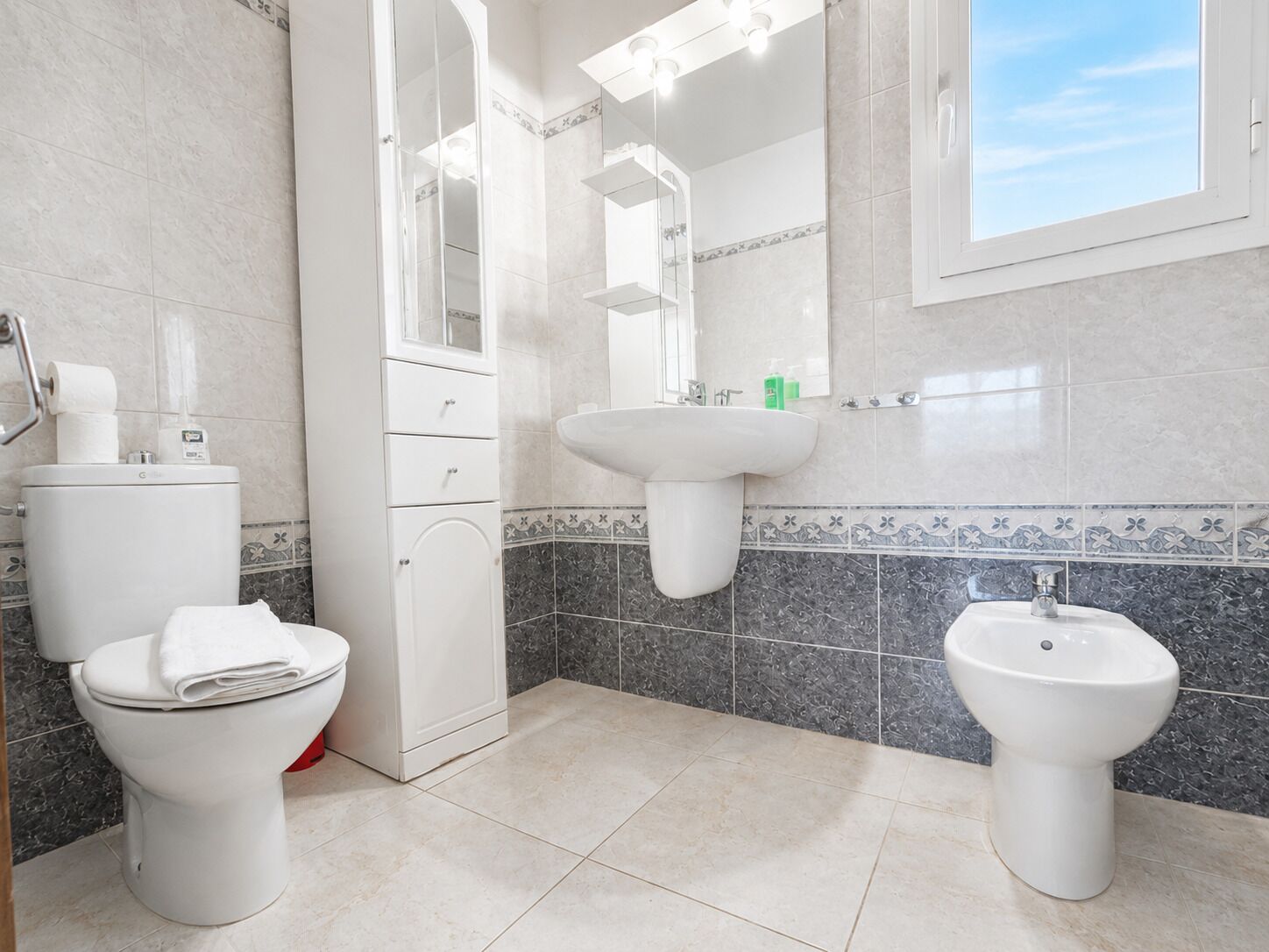 A bathroom with a toilet, bidet, and sink.
