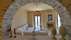 Una habitación con un sofá blanco, una lámpara colgante y una chimenea.
