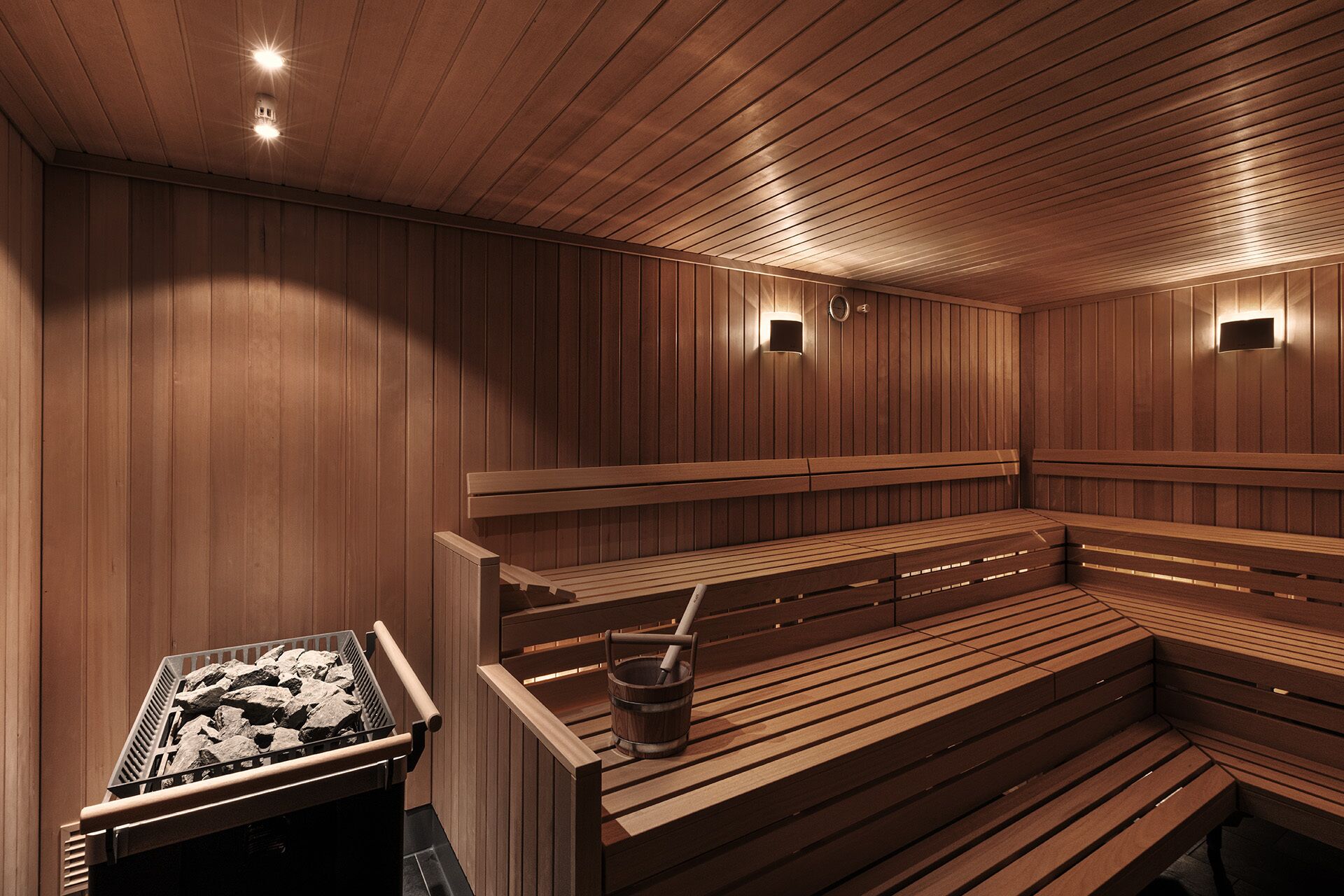 A sauna with wooden benches and a stone heater.