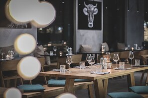 A restaurant interior with wooden tables, chairs, and a bull mural on the wall.