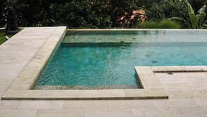 A rectangular swimming pool with a tiled edge, surrounded by a stone deck. - Calma Cliff Villas  (Ungasan)