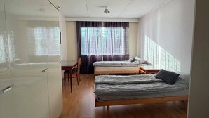 Una habitación con dos camas, un escritorio y una silla.