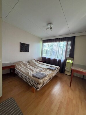 Una habitación con cama, escritorio, ventana con cortinas, ventilador de techo e iluminación empotrada en la pared.