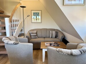 A modern living room with a sofa, two armchairs, a coffee table, and a floor lamp. - Eidumweg Apartment 4 - Bright and modern upper-floor apartment for 4 people with (Sylt)