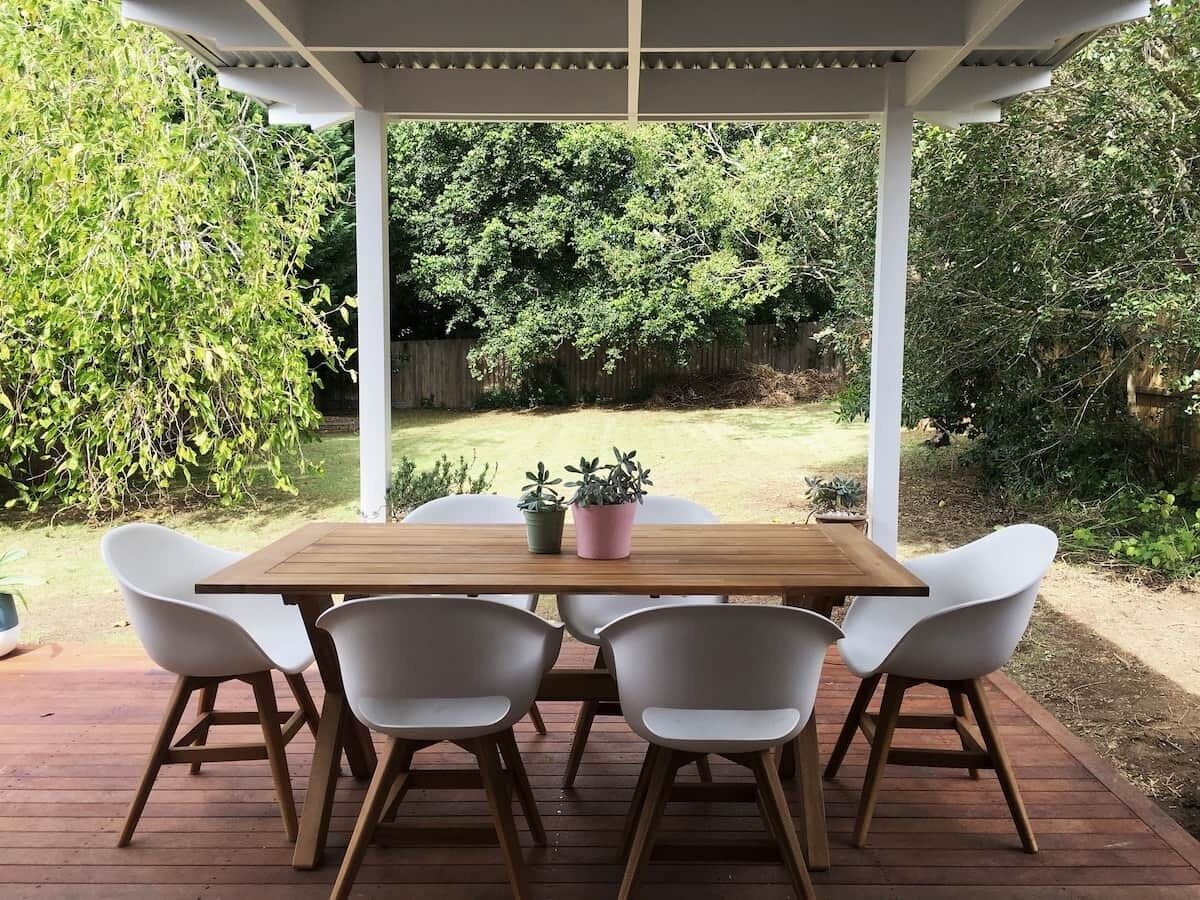 Une terrasse en bois avec une pergola, une table et six chaises.